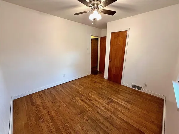 a view of a room with wooden floor and fan