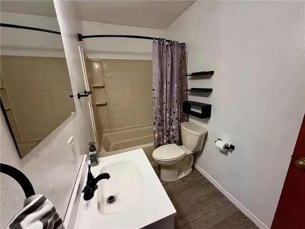 a bathroom with a sink a toilet and shower