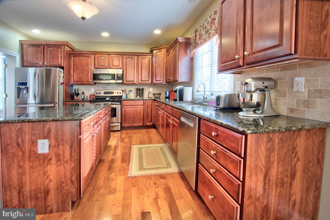 816 Shadebrush Ridge Road West Chester, PA 19382 - Photo 18 of 44 a kitchen with stainless steel appliances granite countertop a sink a stove and a refrigerator