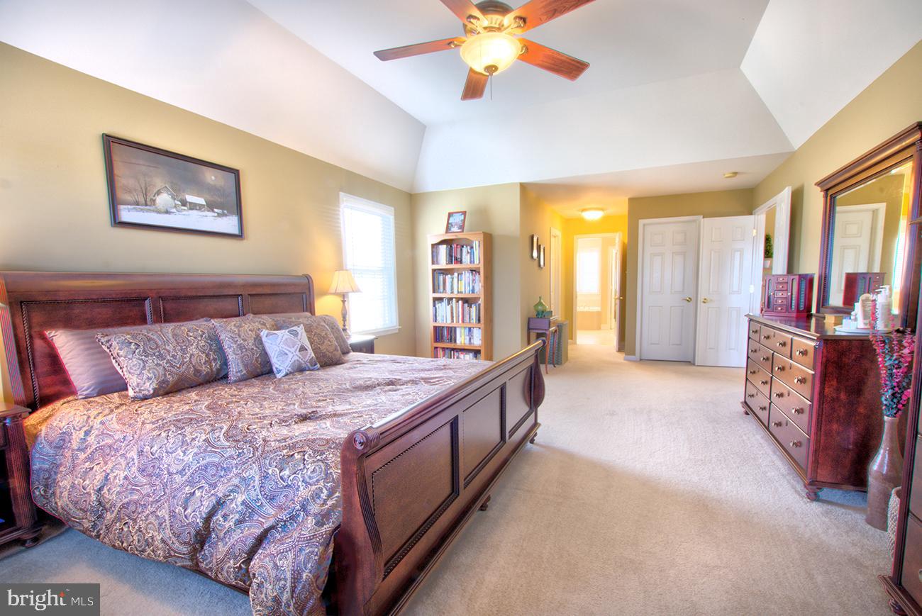 816 Shadebrush Ridge Road West Chester, PA 19382 - Photo 28 of 44 a large bedroom with a bed and a chandelier