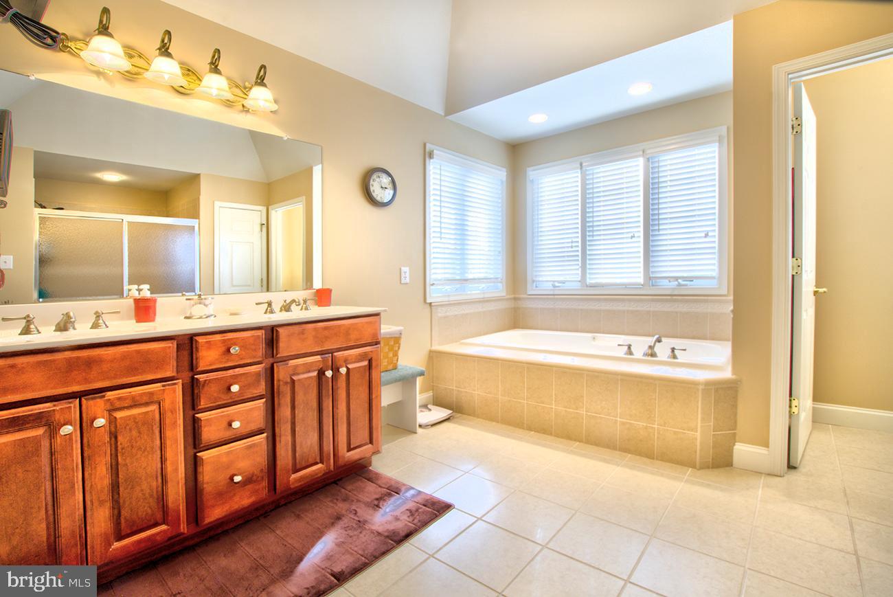 816 Shadebrush Ridge Road West Chester, PA 19382 - Photo 31 of 44 a spacious bathroom with a tub a double vanity sink and a large mirror
