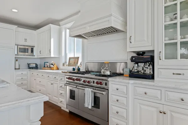 a kitchen with white cabinets and appliances