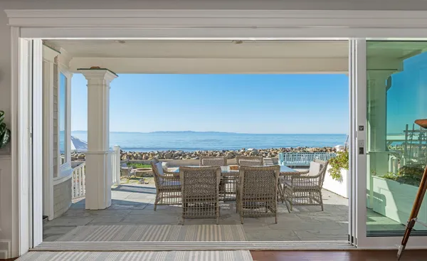 a view of a balcony with dining table and chairs