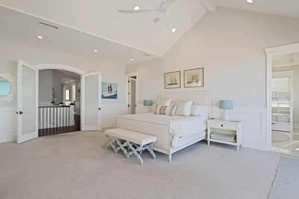 a spacious bedroom with a bed and a lamp