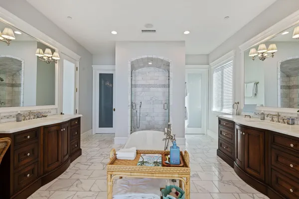 a spacious bathroom with a double vanity sink a large mirror and a shower