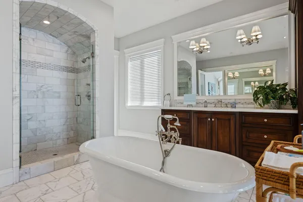 a bathroom with a granite countertop tub sink and mirror