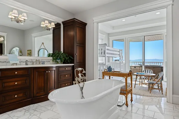 a spacious bathroom with a granite countertop sink and a bathtub