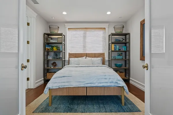 a bedroom with a bed and a book shelf
