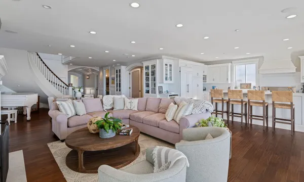 a living room with furniture and a dining table with wooden floor