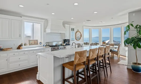 a kitchen with stainless steel appliances granite countertop a table chairs sink and cabinets