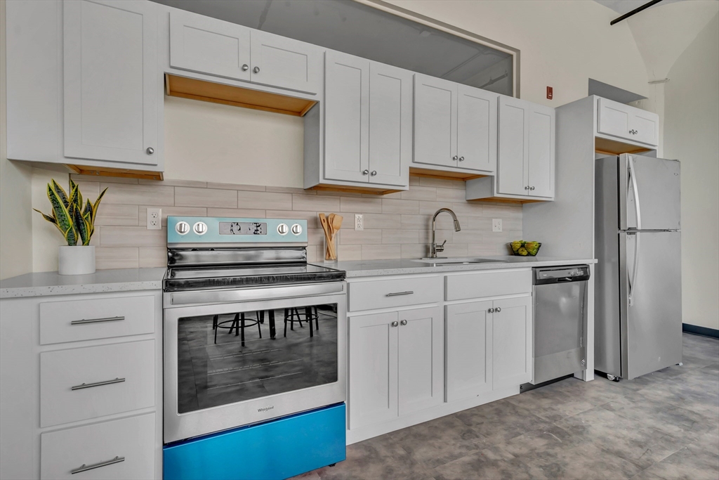 151 Chestnut Street, Unit 301 Springfield, MA 01103 - Photo 11 of 12 a kitchen with stainless steel appliances granite countertop a stove a sink and a refrigerator