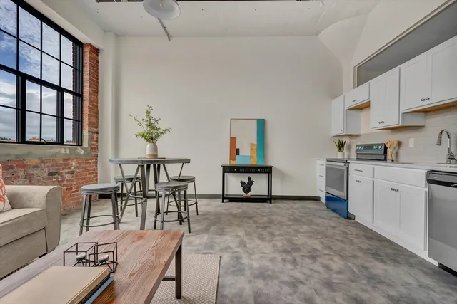 a living room with furniture a flat screen tv and a dining table