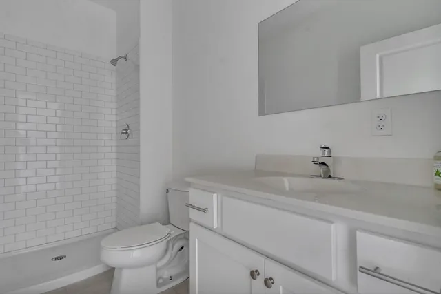 a bathroom with a sink a toilet and shower