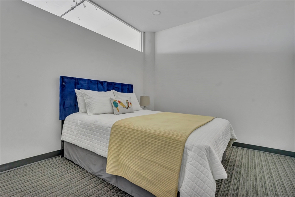 151 Chestnut Street, Unit 301 Springfield, MA 01103 - Photo 4 of 12 a bedroom with a bed and wooden floor