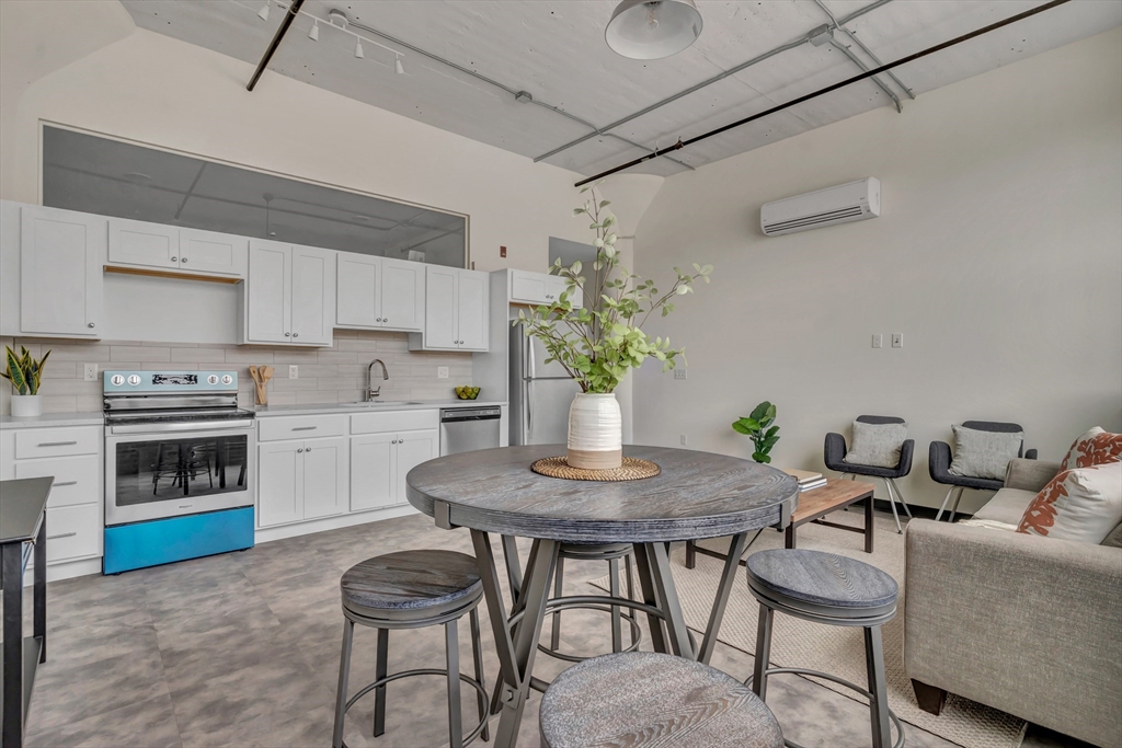 151 Chestnut Street, Unit 301 Springfield, MA 01103 - Photo 8 of 12 a kitchen with a table chairs stove and microwave