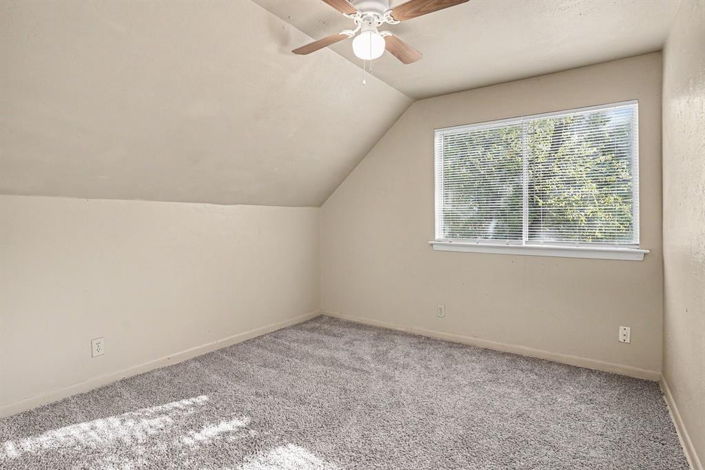 1414 Finley Road Irving, TX 75062 - Photo 21 of 27 Sloped ceiling room featuring a ceiling fan, recessed window with blinds, and gray carpeting