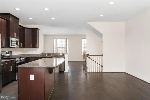 a view of an empty room with a kitchen and a window
