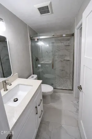 a bathroom with a toilet sink and shower