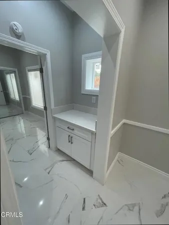 an empty room with windows and refrigerator