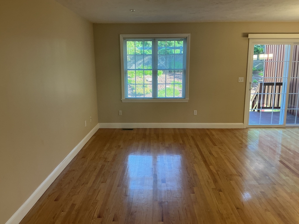 19 Village Way, Unit 19 Rutland, MA 01543 - Photo 6 of 18 an empty room with wooden floor and windows