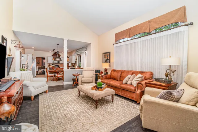 a living room with furniture wooden floor and a large window