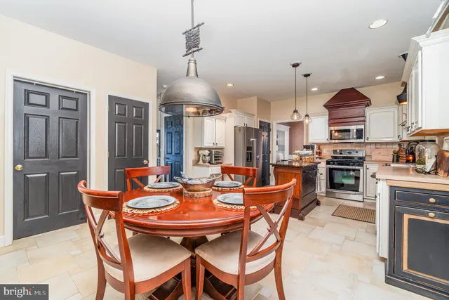 a view of a dining room and livingroom with furniture wooden floor a chandelier