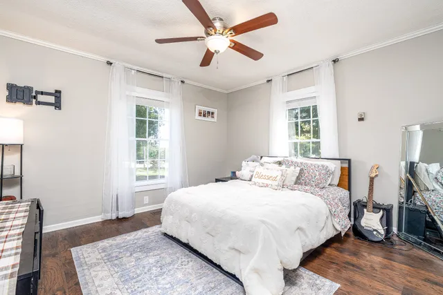a bedroom with a large bed chandelier and a window