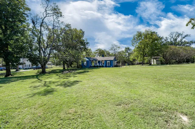 a view of a yard with a house in the background