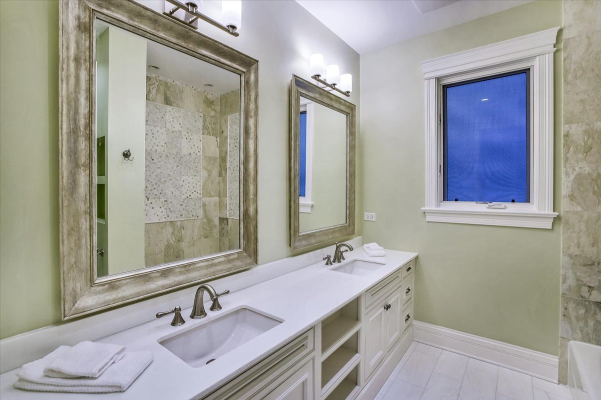 1445 West Wolfram Street Chicago, IL 60657 - Photo 35 of 69 a bathroom with a double vanity sink a mirror and a shower