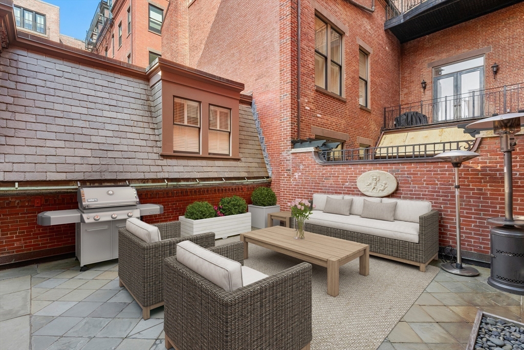 3 Commonwealth Avenue, Unit 1 Boston, MA 02116 - Photo 13 of 30 a view of a patio with couches table and chairs and potted plants