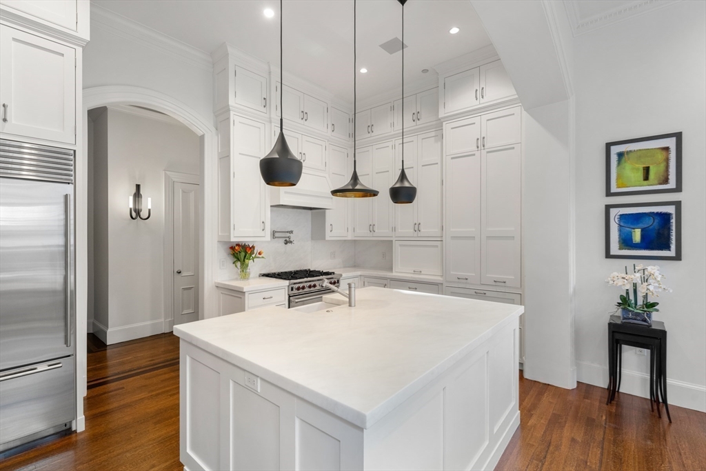 3 Commonwealth Avenue, Unit 1 Boston, MA 02116 - Photo 8 of 30 a kitchen with a sink a refrigerator and wooden floor