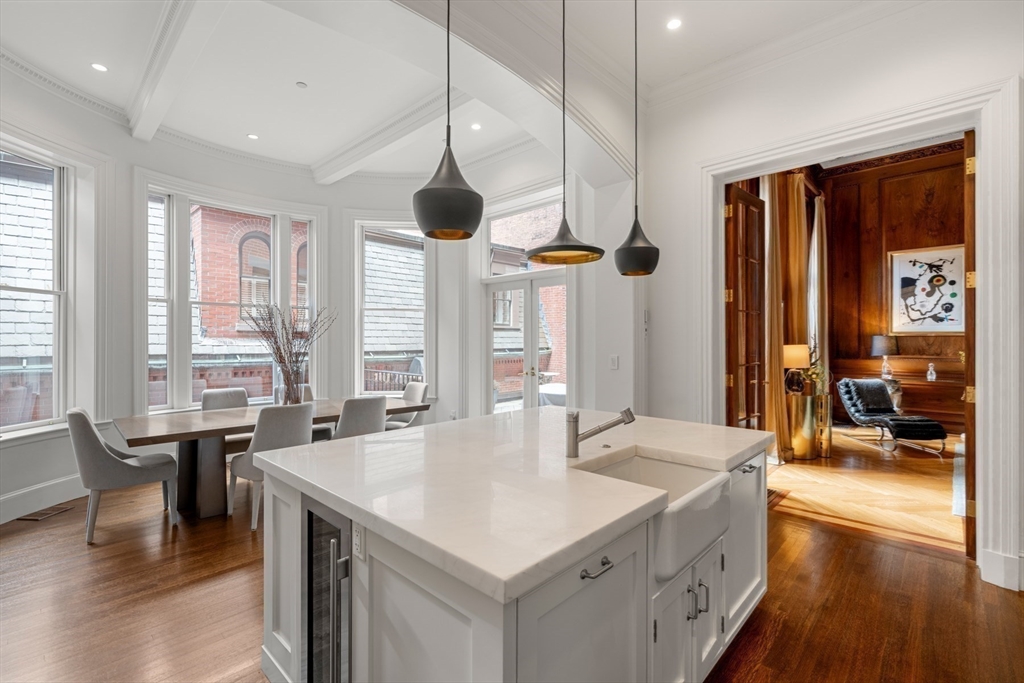 3 Commonwealth Avenue, Unit 1 Boston, MA 02116 - Photo 10 of 30 a large white kitchen with a large window and stainless steel appliances