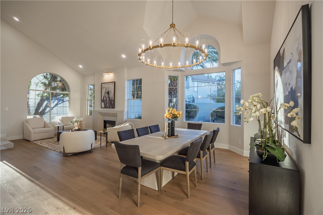 8800 Lusso Las Vegas, NV 89134 - Photo 23 of 85 Dining area featuring vaulted ceiling, wood-type flooring, a fireplace, and hanging lights