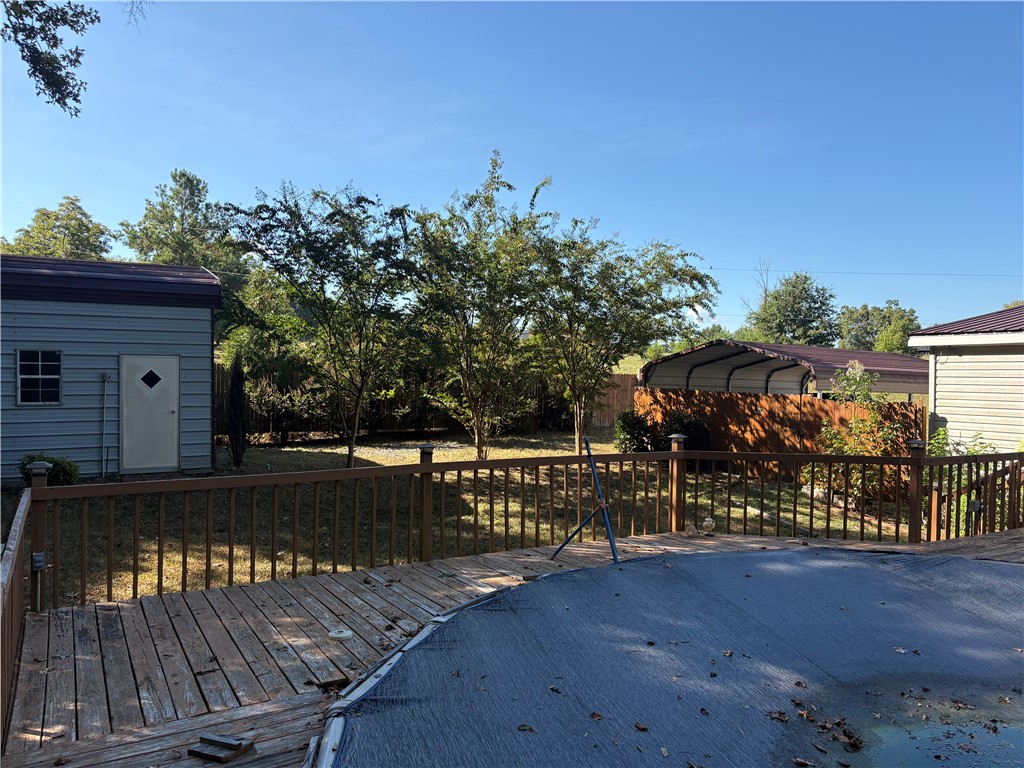 1108 Trotter Road Anderson, SC 29626 - Photo 19 of 27 A spacious wooden deck overlooks a fenced backyard complete with a storage shed and swimming pool.
