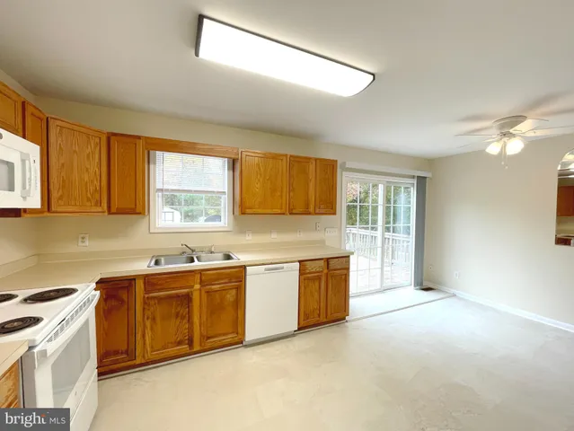 a large kitchen with stainless steel appliances granite countertop a sink stove and cabinets
