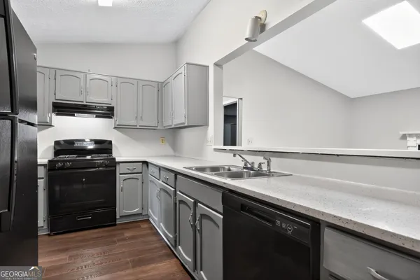 a kitchen with a sink appliances and cabinets