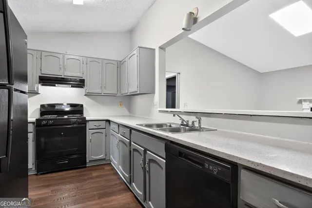 a kitchen with a sink appliances and cabinets