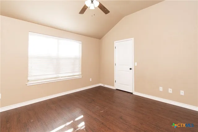 an empty room with a window and wooden floor
