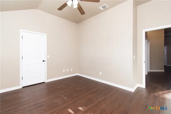 a view of an empty room with wooden floor