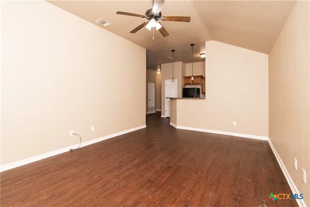 a view of a kitchen with wooden floor and a ceiling fan