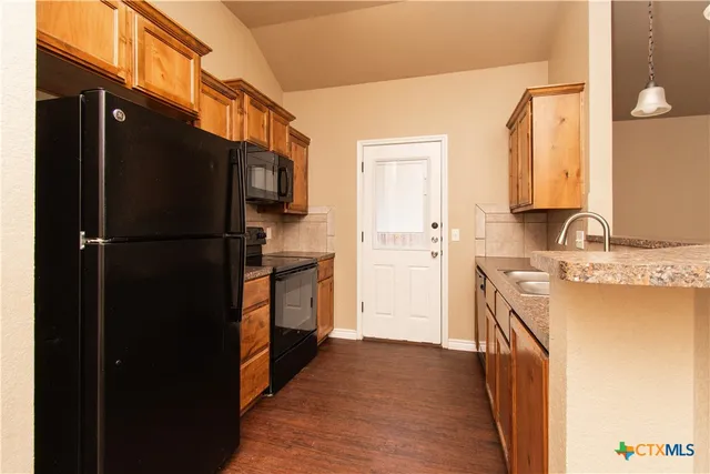 a kitchen with a refrigerator and a sink