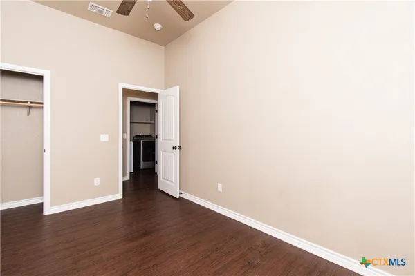 an empty room with wooden floor and closet
