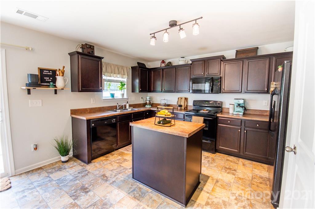 129 Mossy Pond Road Statesville, NC 28677 - Photo 18 of 47 a kitchen with kitchen island granite countertop a sink counter top space appliances and a window