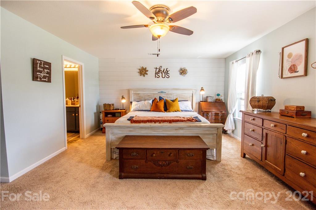 129 Mossy Pond Road Statesville, NC 28677 - Photo 23 of 47 a bed room with a bed and a chandelier