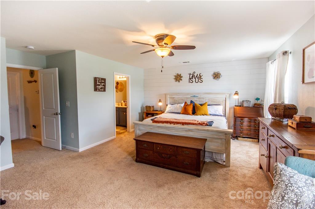 129 Mossy Pond Road Statesville, NC 28677 - Photo 24 of 47 a bedroom with furniture and a chandelier