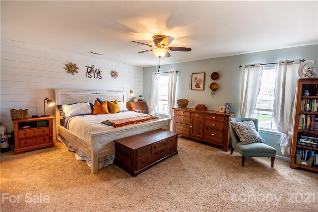 129 Mossy Pond Road Statesville, NC 28677 - Photo 25 of 47 a bedroom with a bed and a chandelier
