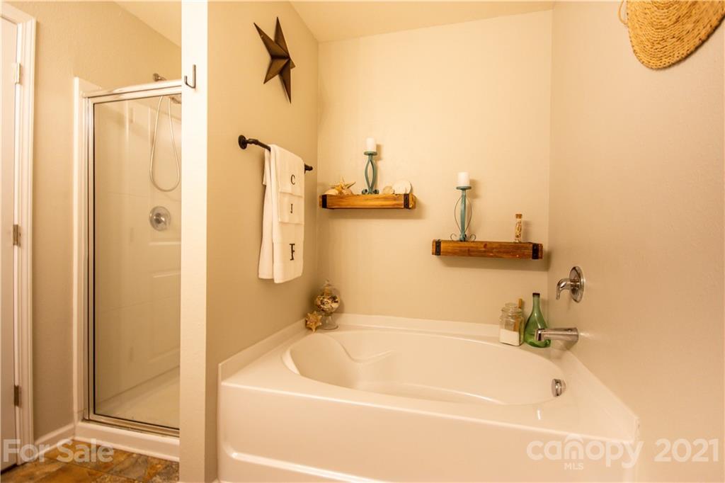129 Mossy Pond Road Statesville, NC 28677 - Photo 30 of 47 a bathroom with a tub a sink and a shower