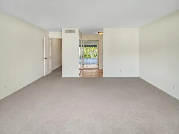 a view of a hallway with wooden floor and closet