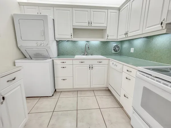 a large white kitchen with white cabinets and white appliances