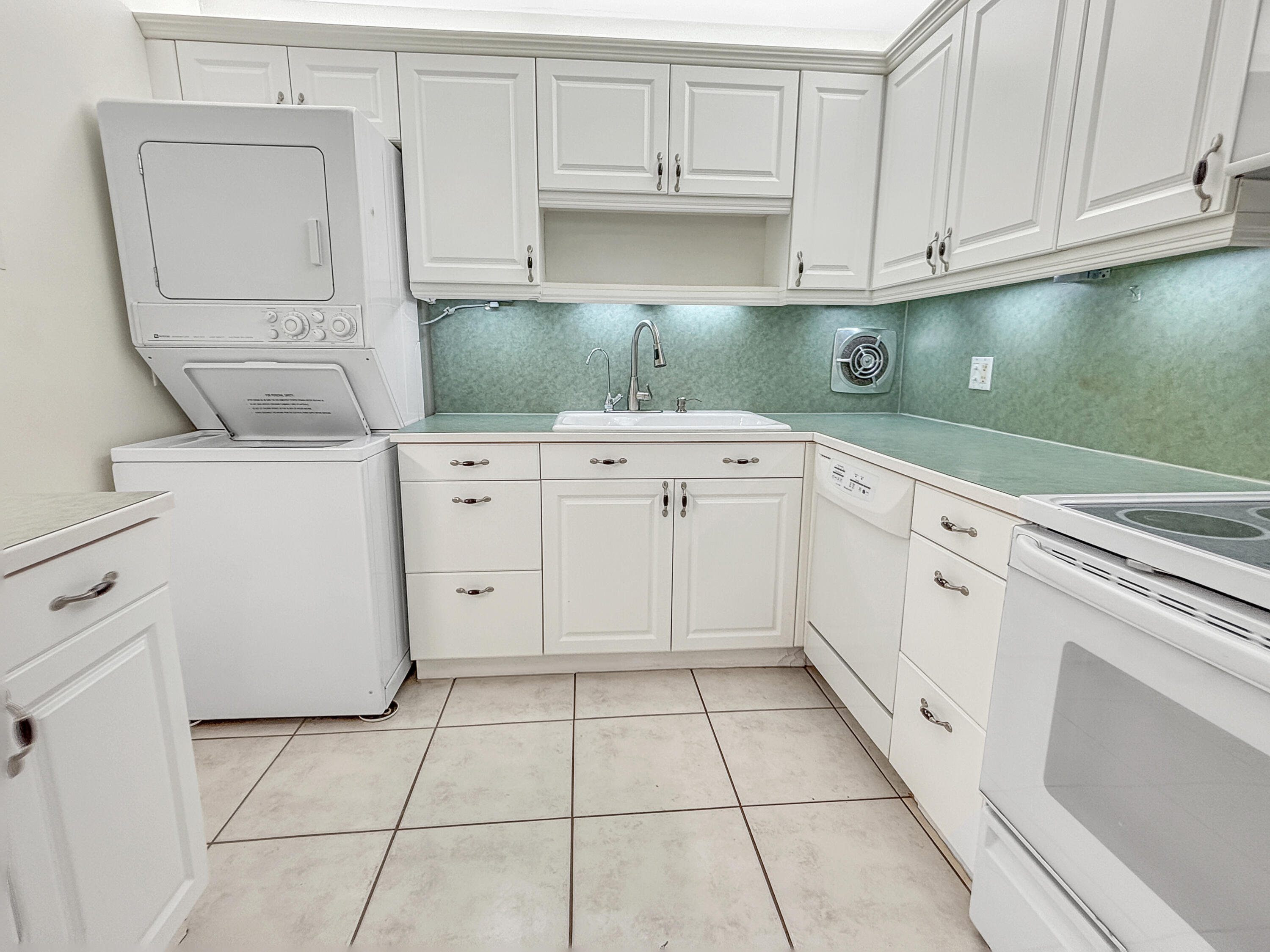 390 Golfview Road, Unit G North Palm Beach, FL 33408 - Photo 5 of 36 a kitchen with white cabinets and white appliances